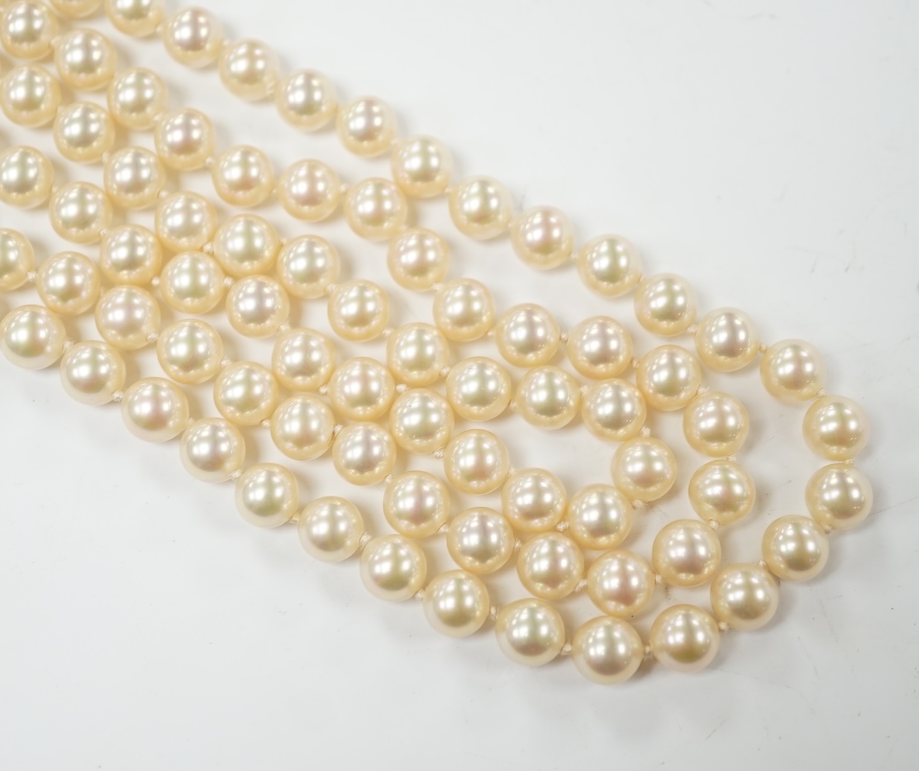 A late 1950's triple strand simulated pearl necklace, with garnet cluster set 9ct gold clasp, 66cm. Condition - fair